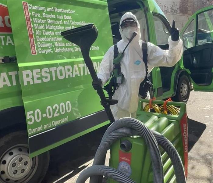 Photo of SERVPRO of Augusta crew member holding up a peace sign by a company van. 